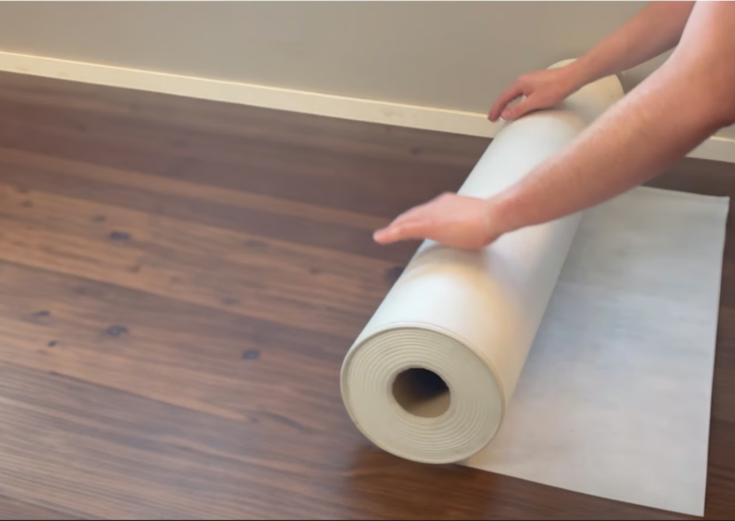 Stucloper beschermt een houten vloer tegen verf en vuil tijdens renovatiewerkzaamheden.